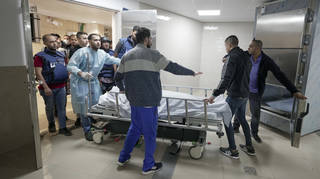 Journalists and medics wheel the body of Shireen Abu Akleh, a journalist for Al Jazeera, into a morgue inside a hospital in the West Bank town of Jenin