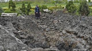 Orthodox Sister Evdokia gestures in front of the crater of an explosion, after Russian shelling next to the Orthodox Skete in honour of St John of Shanghai in Adamivka, near Slovyansk, in the Donetsk region, Ukraine