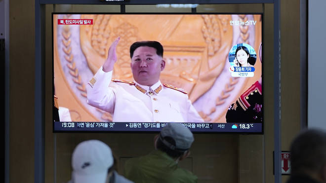 People watch a TV screen showing a news program reporting about North Korea’s missile launch with file footage of North Korean leader Kim Jong Un at a train station in Seoul, South Korea