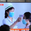 People watch a TV screen showing a news report about the COVID-19 outbreak in North Korea, at a train station in Seoul, South Korea, on Saturday