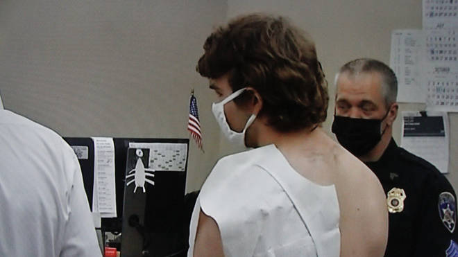 The 18-year-old white supremacist appeared before a judge in a paper medical gown and was arraigned on murder charges.