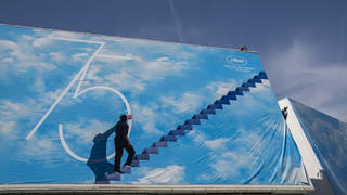 A festival worker places the official poster during preparations for the 75th international film festival in Cannes, southern France