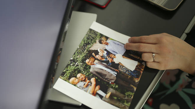 Uyghur Nursimangul Abdureshid, 34, shows a photograph of her family during an interview with The Associated Press