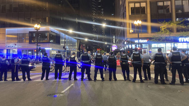 Chicago police block traffic near State and Monroe streets after crowds of young people flooded the Loop after a fatal shooting in Millennial Park in Chicago