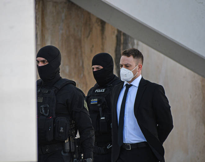 Babis Anagnostopoulos arrives at the court escorted by police for his trial in Athens.