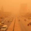 People navigate a street during a sandstorm in Baghdad, Iraq