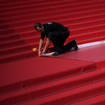 Crew members install the red carpet at the Palais des Festivals ahead of the opening day of the 75th international film festival, Cannes (Daniel Cole/AP)