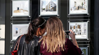People looking in an estate agent's window