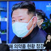People watch a TV screen showing a news program reporting with an image of North Korean leader Kim Jong Un