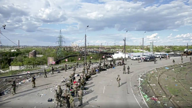 In this photo taken from video released by the Russian defence ministry, Ukrainian servicemen line up to be checked as they leave the besieged Azovstal steel plant in Mariupol