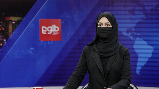 TV presenter Khatereh Ahmadi wears a face covering as she reads the news