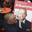 Anthony Albanese signs a poster at a coffee shop in Sydney