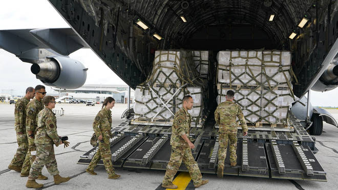 Crew members of a C-17 aircraft unload the baby formula cargo at the Indianapolis International Airport