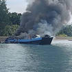Smoke billows from the M/V Mercraft 2 ferry as it is towed to an island off the town of Real, Quezon province, Philippines