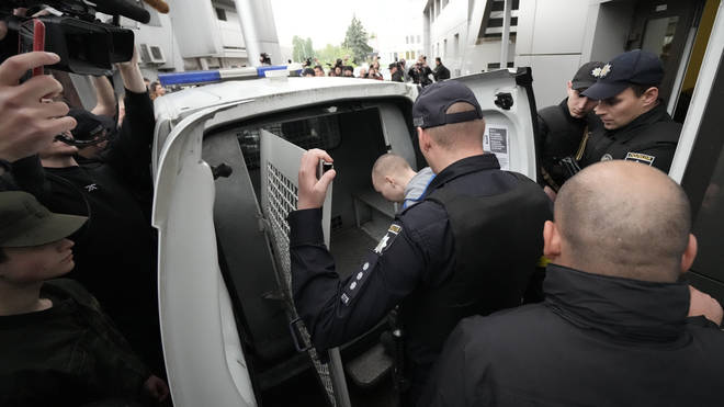 Shishimarin is put into the back of a police van after being sentenced