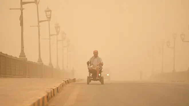 A man navigates his wheelchair on a street during a sand storm in Baghdad, Iraq, on Monday May 23 2022