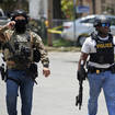 Police walk near Robb Elementary School following a shooting in Uvalde, Texas