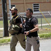 Police walk near Robb Elementary School following a shooting