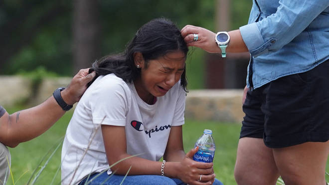 A girl cries, comforted by two adults, outside the Willie de Leon Civic Center where grief counseling will be offered