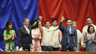 Ferdinand Marcos Jr, centre, raises hands