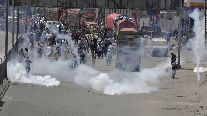 Police fire tear gas to disperse supporters of Pakistan’s key opposition party marching towards Islamabad
