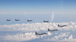 Three F-15 warplanes of the Japanese self-defence force, front, and four F-16 fighters of the US armed forces fly over the Sea of Japan