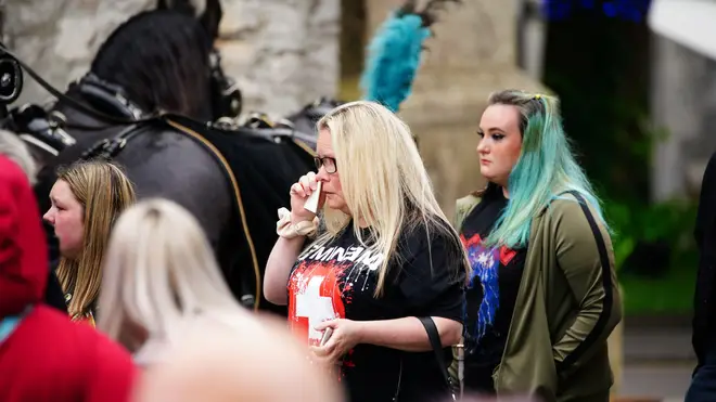 Mourners wearing band t-shirts wept as the 18-year-old's procession arrived at church