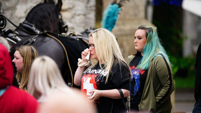 Mourners wearing band t-shirts wept as the 18-year-old's procession arrived at church