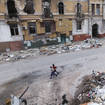 Children walk among buildings destroyed during fighting in Mariupol
