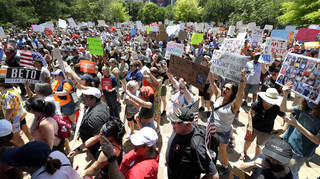 Protesters hold a rally at Discovery Green Park, across the street from the National Rifle Association Annual Meeting held at the George R. Brown Convention Center Friday, May 27, 2022, in Houston.