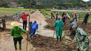 People work on a flooded field