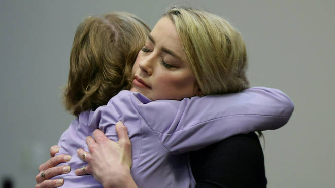 Amber Heard hugs her lawyer after the jury said that they believe she defamed Johnny Depp