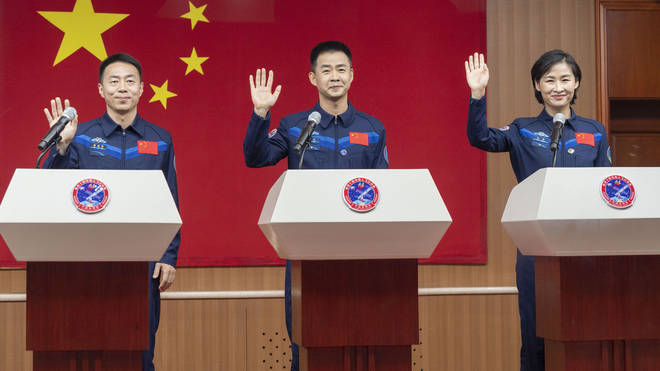 Cai Xuzhe, Chen Dong and Liu Yang wave as they attend a press conference for the upcoming Shenzhou-14 mission