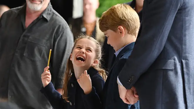 Princess Charlotte laughs as she conducts a band next to her brother