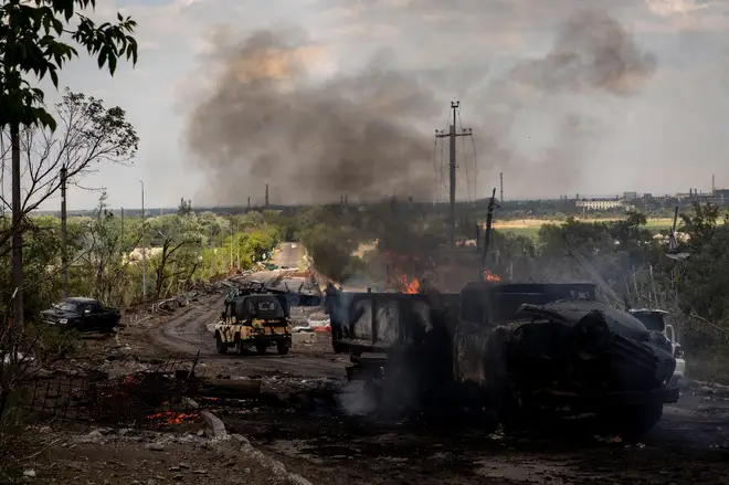 A destroyed truck can be seen on fire at the bridge connecting Severodoonetsk and Lysychansk, in Ukraine's Luhansk region