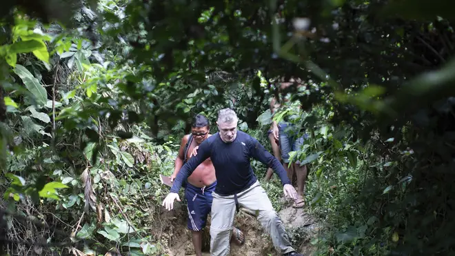 British journalist Dom Phillips, right, and a Yanomami indigenous man walk in Roraima state, Brazil, in 2019
