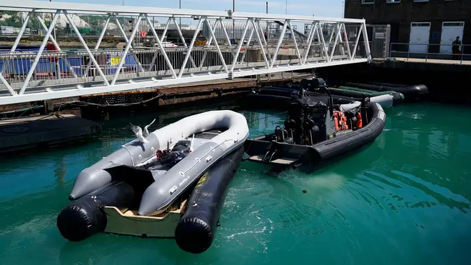 Inflatable boats are towed into the marina after a group of people thought to be migrants are brought in to Dover