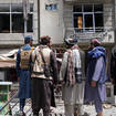 Taliban fighters gather at the site of an explosion in front of a Sikh temple in Kabul