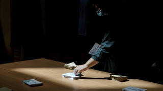 A voter picks up ballots before voting in the second round of the French parliamentary election in Lyon, central France