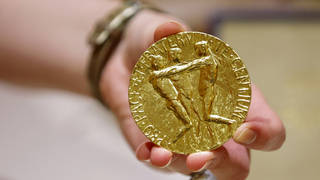 A worker holds Russian journalist Dmitry Muratov’s 23-karat gold medal of the 2021 Nobel Peace Prize before being auctioned at the Times Center, Monday, June 20, 2022, in New York.