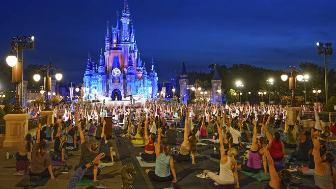 Nearly 2,000 cast members practise sunrise yoga celebrating International Yoga Day in front of Cinderella Castle at the Magic Kingdom Park at Walt Disney World in Lake Buena Vista, Florida