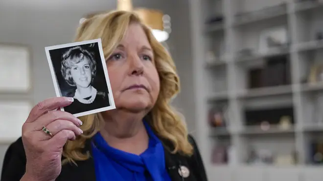 Nassau County district attorney Anne Donnelly holds a photo of Diane Cusick during an interview with The Associated Press