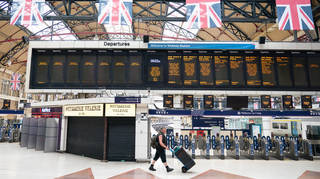 A man passes departure boards at London Victoria
