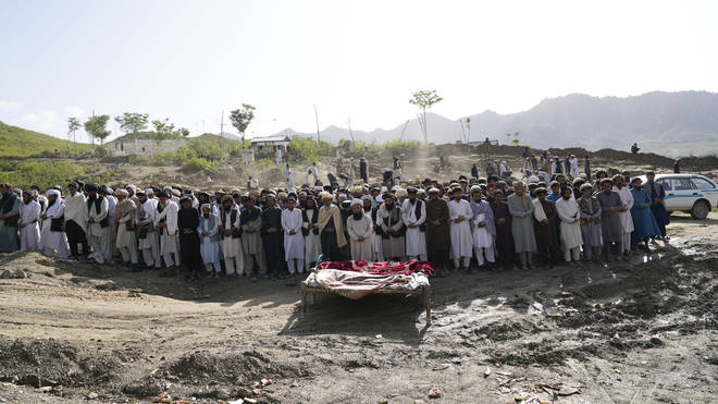 Afghans pray for relatives killed in the earthquake at a burial site in Gayan village, Paktika province