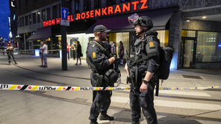 Police stand guard outside a bar in central Oslo