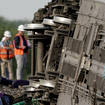 Workers at the scene where an Amtrak train was derailed after striking a lorry