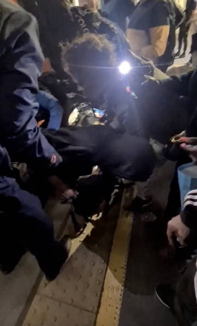 Video, thought to have been filmed late last night or early this morning at the overground station in Walthamstow in east London, shows rescuers kneeling down on the platform edge and encouraging the man to climb upwards.