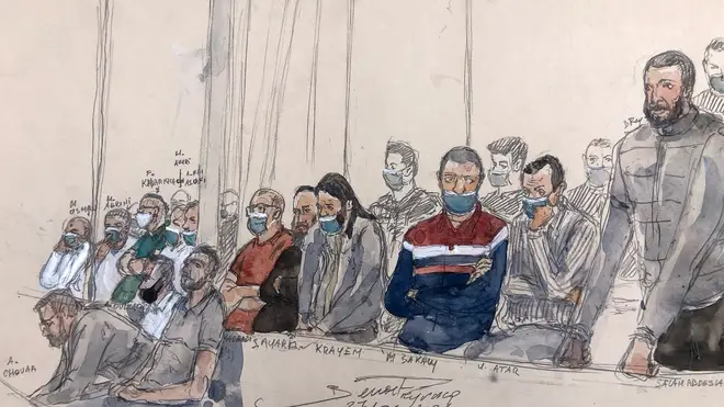 Salah Abdeslam (R) standing next to the 13 other defendants in front of Paris' criminal court