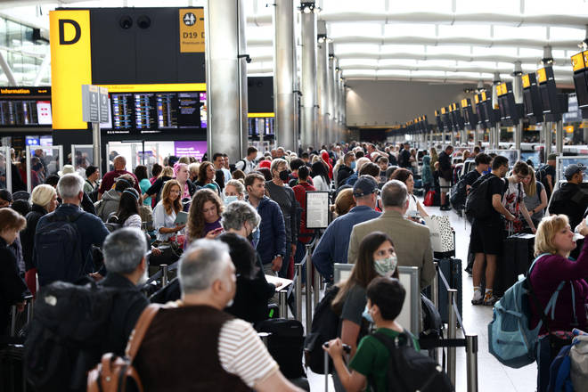 Passengers queue inside the departures terminal at Heathrow Airport.