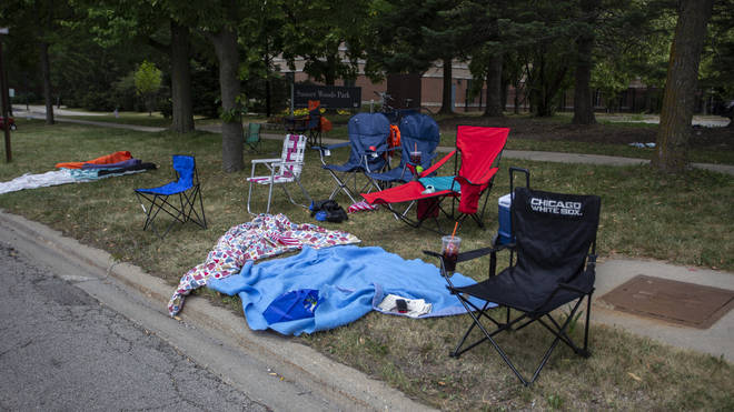 Highland Park Police initially said in a statement that five people had been killed and 19 people were taken to hospital, but those numbers were revised soon after at the news conference (pictured, camp chairs abandoned at the side of the road)